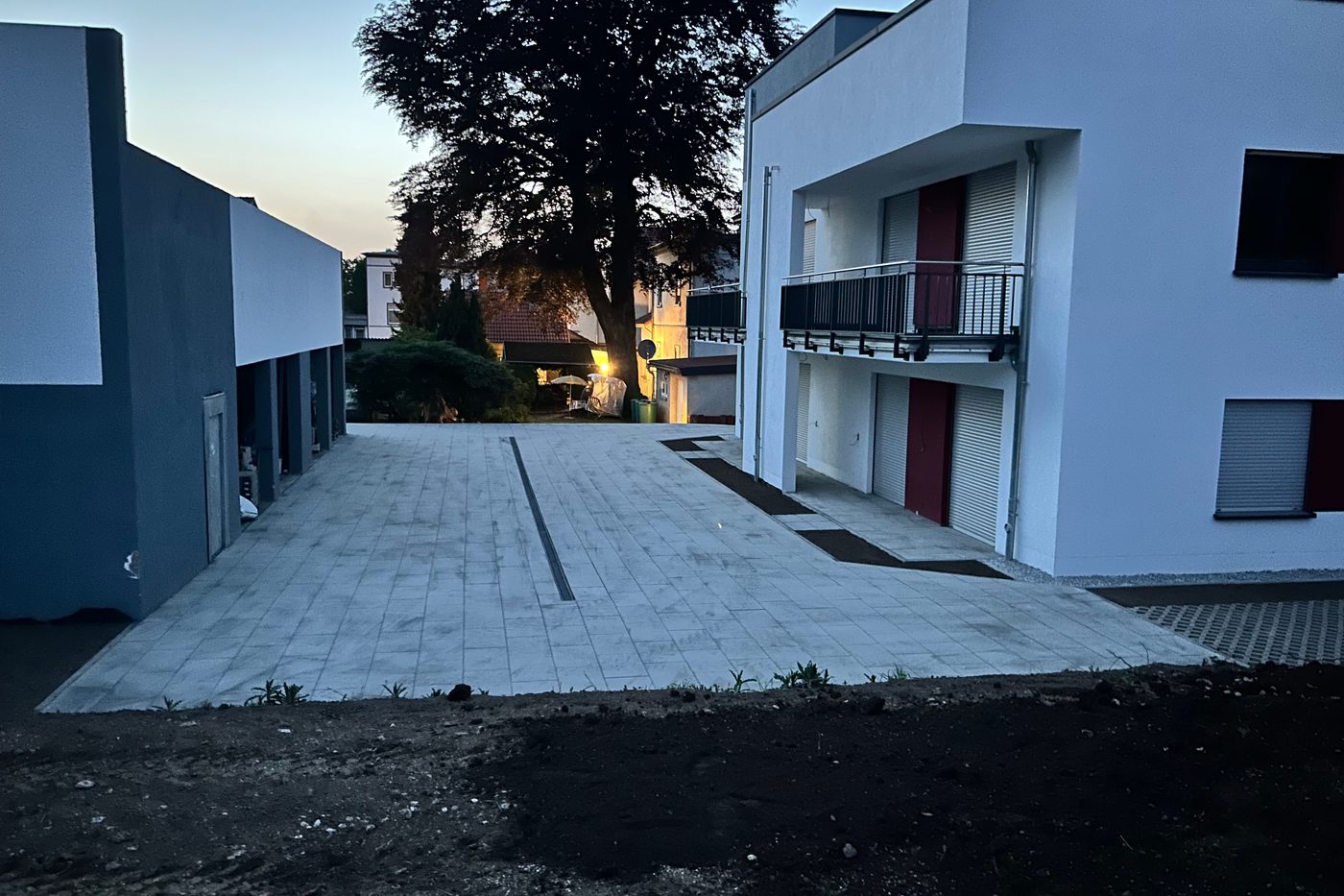 Befestigte Zufahrt zwischen zwei Gebäuden in der Abenddämmerung