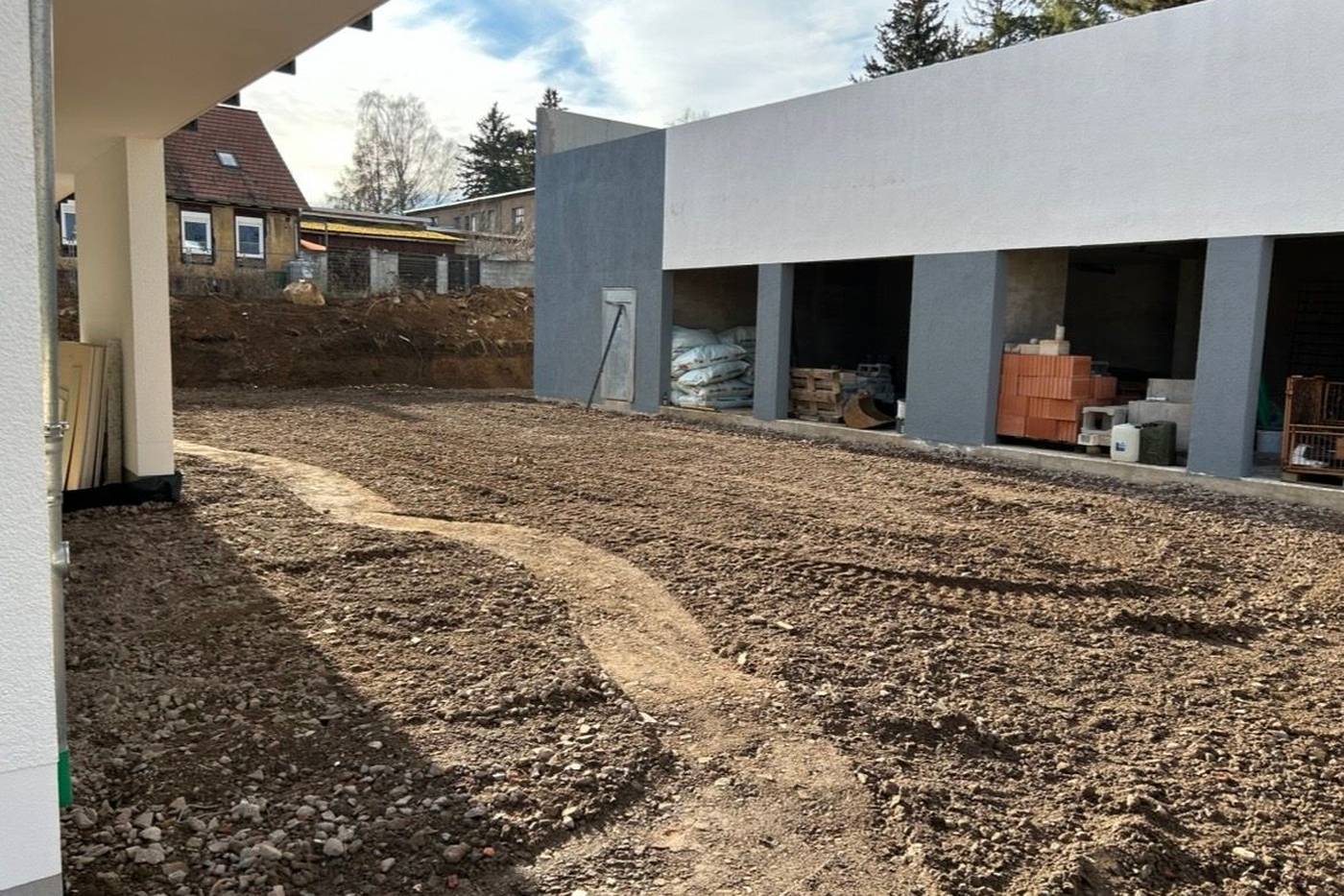 Erdplanum vor einem Rohbau mit Garagen, Boden abgetragen und grob profiliert