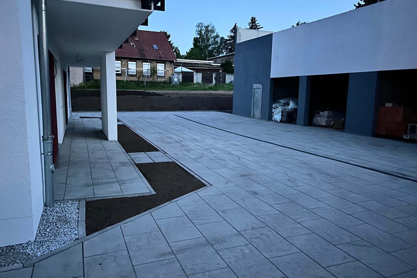 Geschlossene Plattenfläche vor einer Garagenzeile mit sauber ausgerichteten Fugen