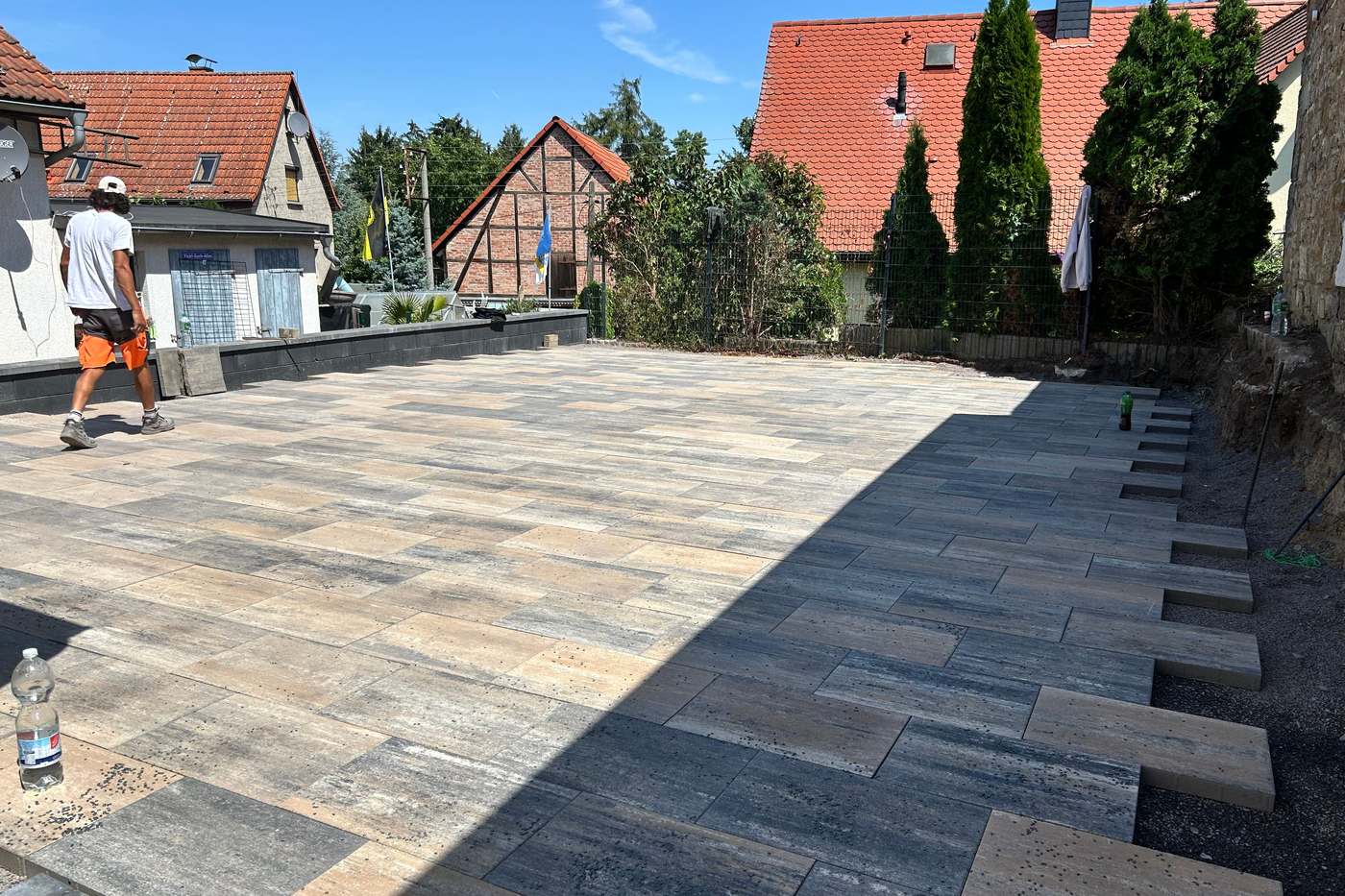 Große Terrassenfläche aus großformatigen Platten mit Blockstufen an der Böschung