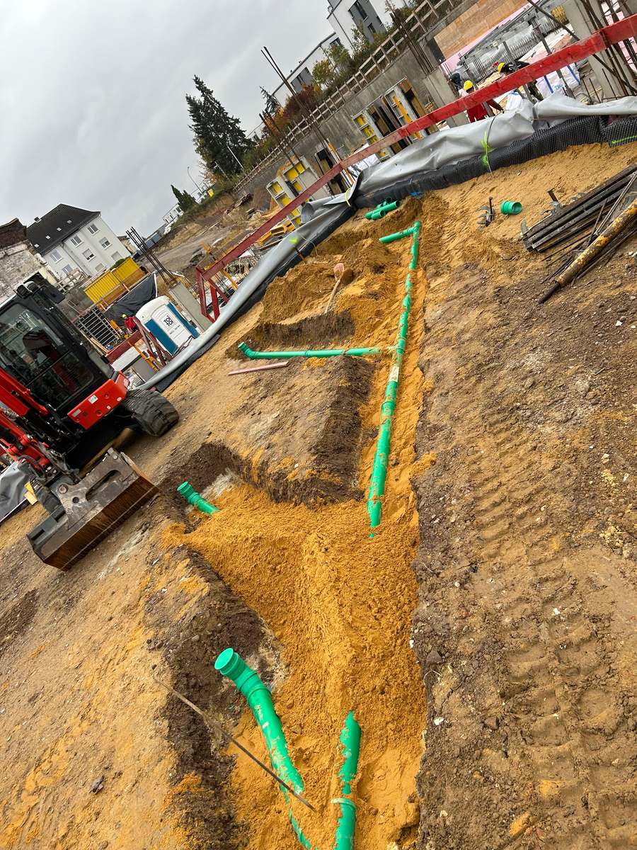 Leitungsgraben mit verlegten Kanalrohren auf einer Baustelle des Betriebs