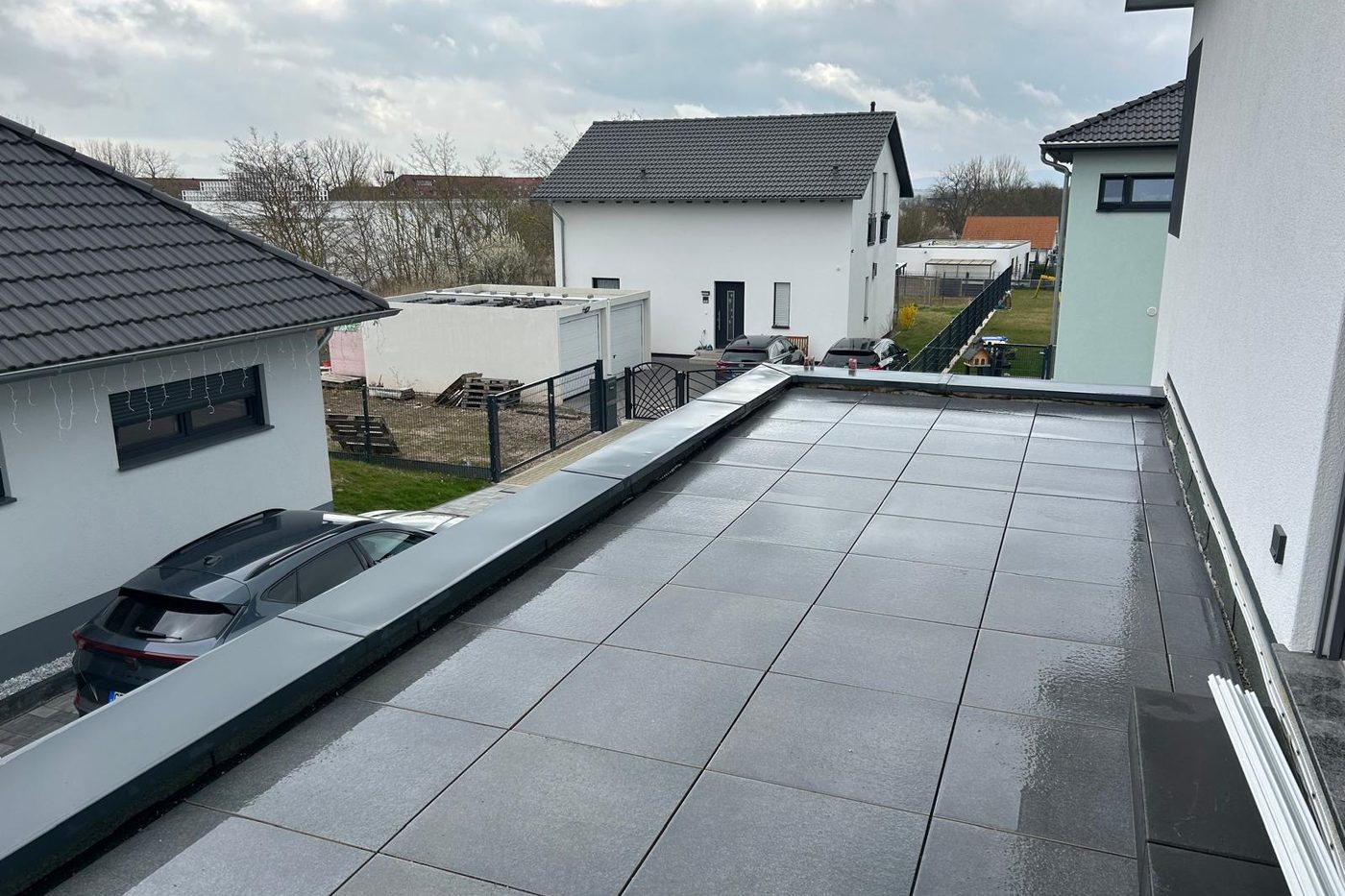 Terrassenfläche aus großformatigen grauen Platten mit umlaufender Randabdeckung